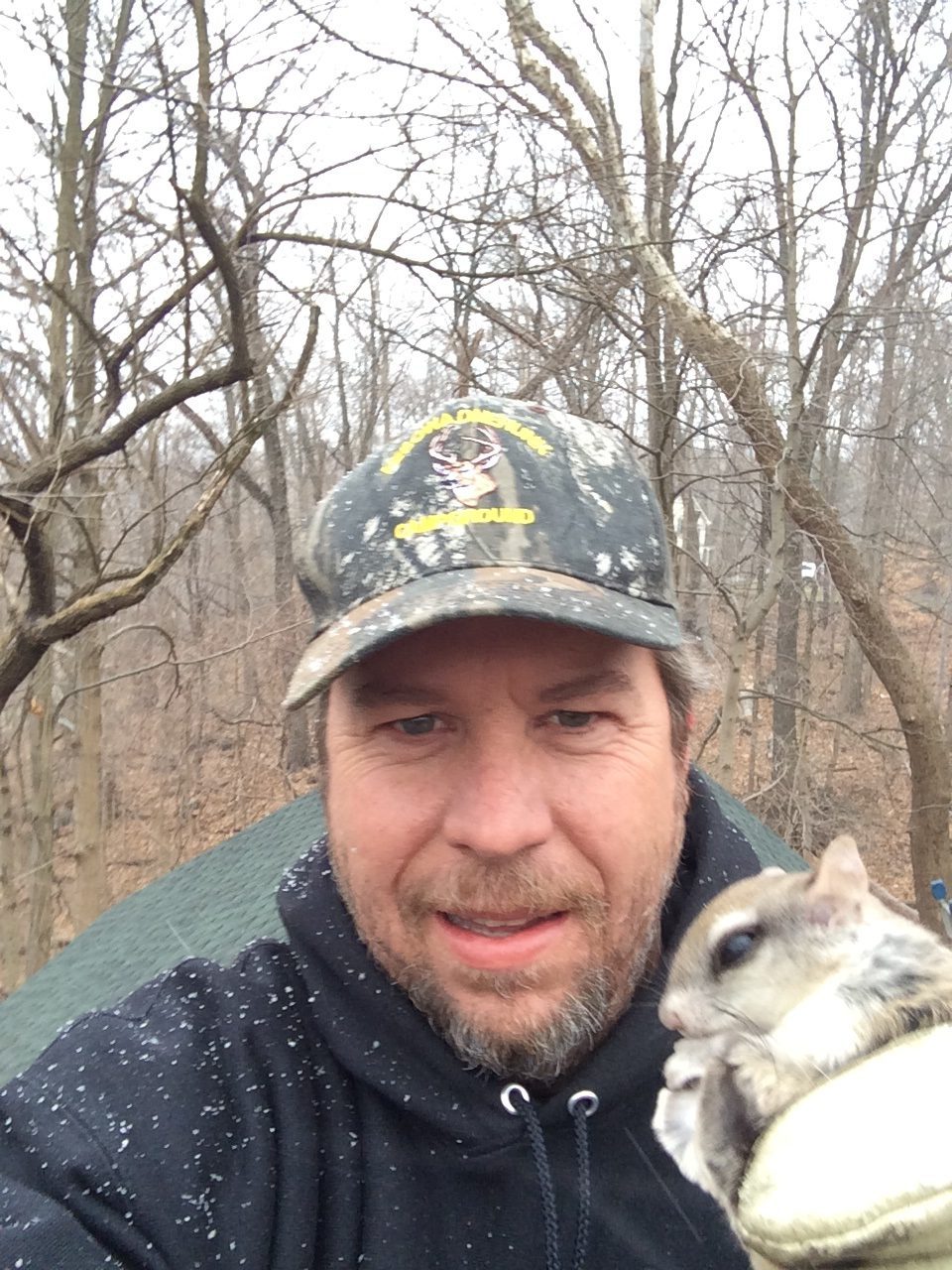 Man holding a small animal outdoors
