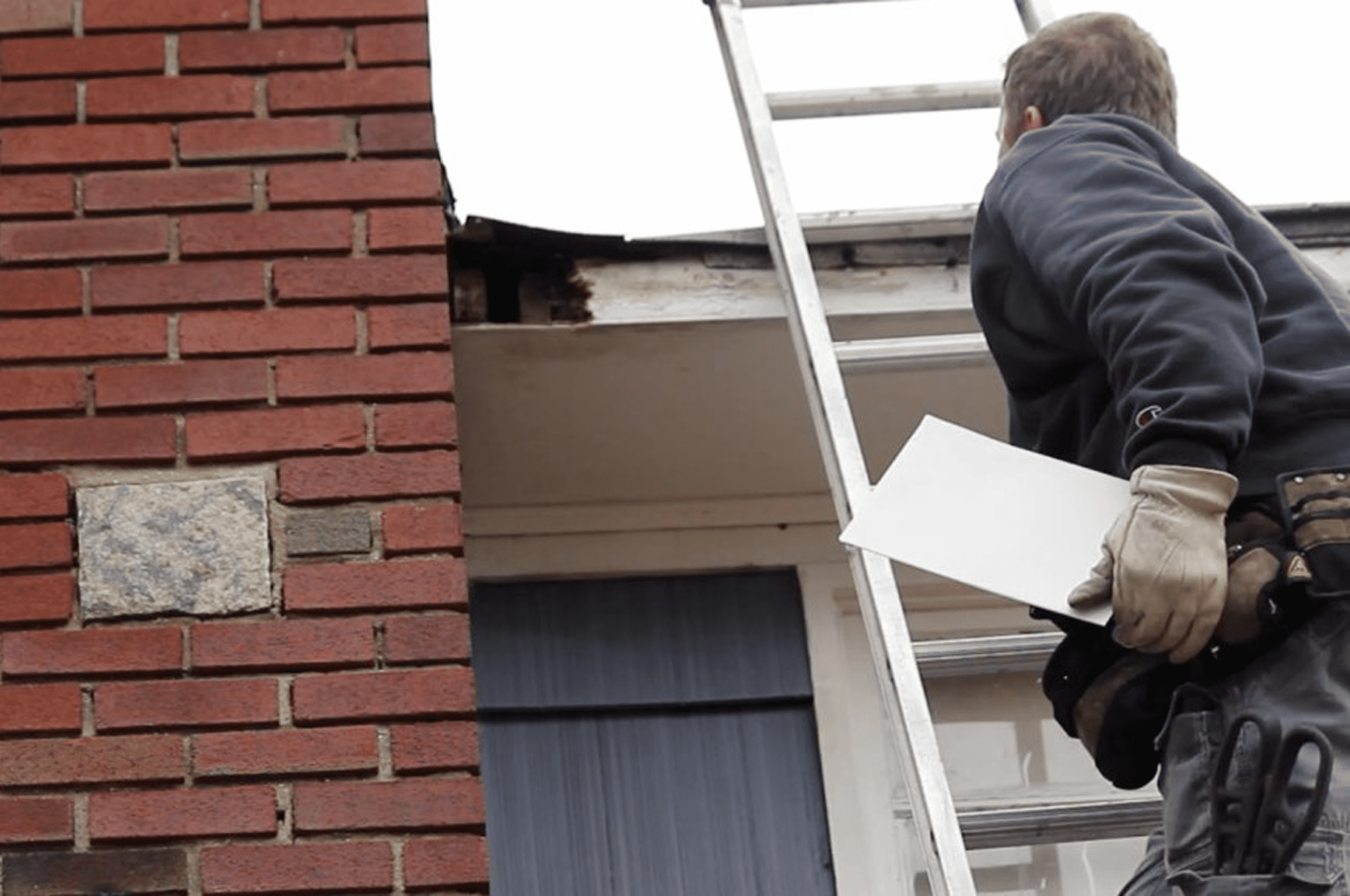 Person holding paper near roof edge